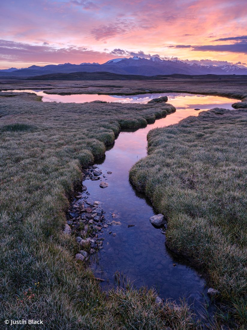 Landscape photo of a stream through the jailoo at sunrise