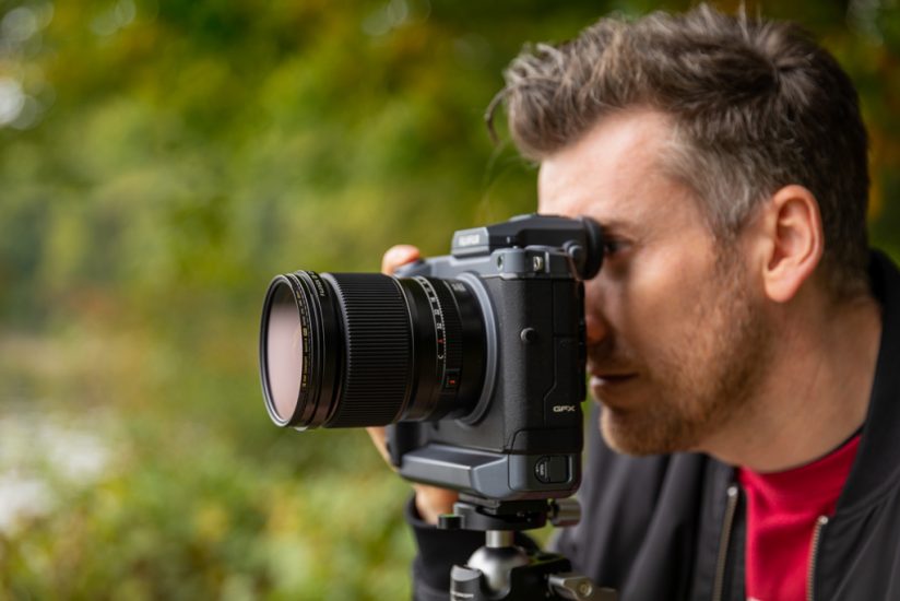 Photo of a photographer looking through a camera viewfinder