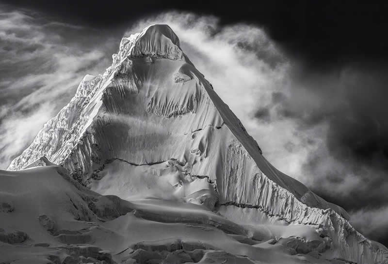 2026 Memorial Maria Luisa Awards: Best Mountain & Nature Photos Revealed 38 Black-and-white image of Alpamayo mountain showing sharp ridges, steep snowy slopes, and dramatic cloud formations.
