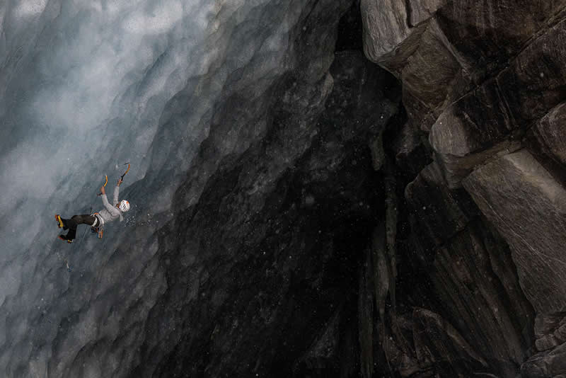 2026 Memorial Maria Luisa Awards: Best Mountain & Nature Photos Revealed 40 A climber falling on a steep icy wall beside a dark rocky cliff, captured mid-air in a dramatic alpine scene.