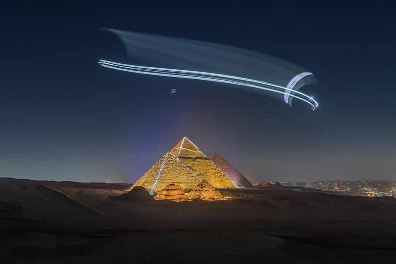 2026 Memorial Maria Luisa Awards: Best Mountain & Nature Photos Revealed 43 Paraglider flying at night above illuminated pyramids, leaving light trails in the sky over a desert landscape.