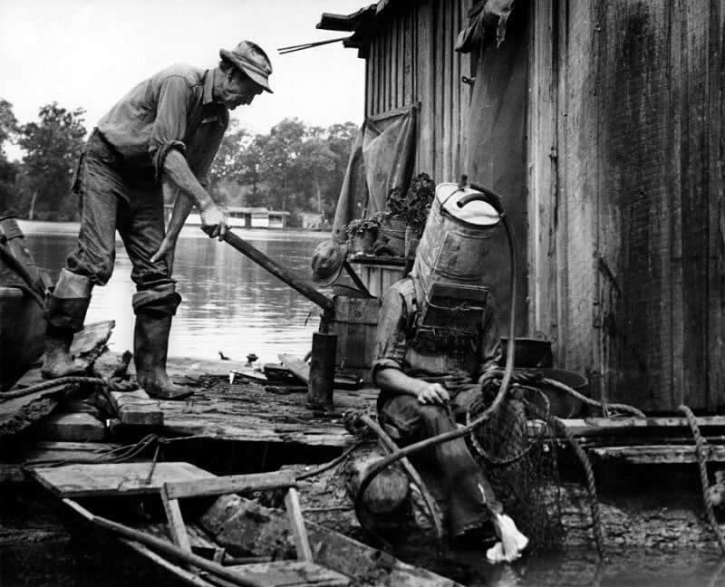 A Mississippi River pearl diver, using a car’s old gas tank for a helmet, prepares to descend into the river, 1938.