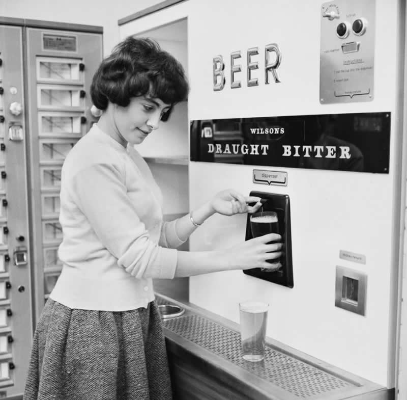 A woman getting a pint of draught bitter (beer) from a vending machine, 1962.