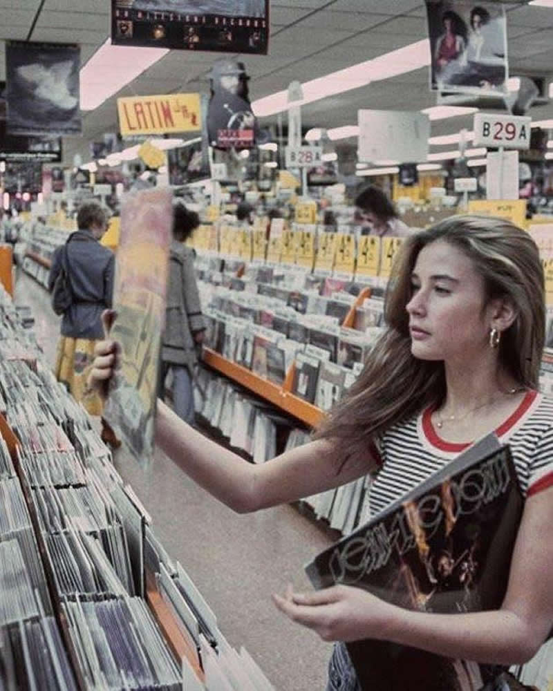 Demi Moore at Tower Records in 1977. She’s holding a Jean Luc Ponty LP titled Imaginary Voyage.