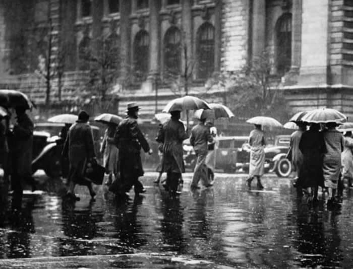 Old New York Revealed: 35 Rare Historical Photos That Capture Forgotten Moments 62 Resilient people walk through the wet streets of New York City during the challenging 1940s.
