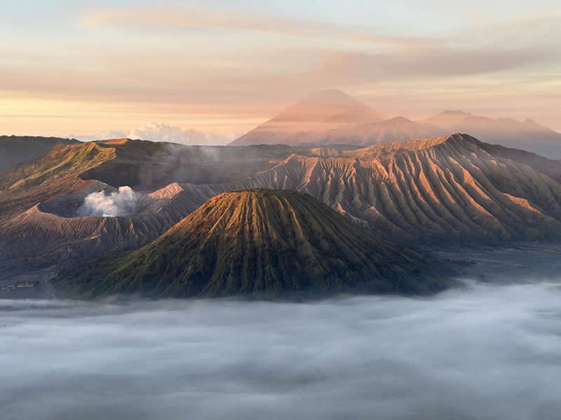 The Mobile Revolution: What the Winners of 35AWARDS Tell Us About the Future of Phone Cameras 42 A panoramic view of volcanic mountains rising above a blanket of clouds during sunrise. Warm golden light highlights the ridged slopes, while distant peaks fade into the horizon. The layered landscape creates a dramatic sense of scale, depth, and natural beauty.