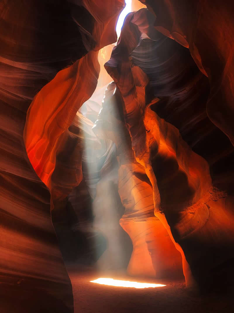 The Mobile Revolution: What the Winners of 35AWARDS Tell Us About the Future of Phone Cameras 54 A narrow sandstone canyon glows with rich orange and red hues as a powerful beam of sunlight streams through an opening above. The illuminated dust and flowing rock formations create a dramatic, ethereal scene filled with depth, texture, and natural beauty.