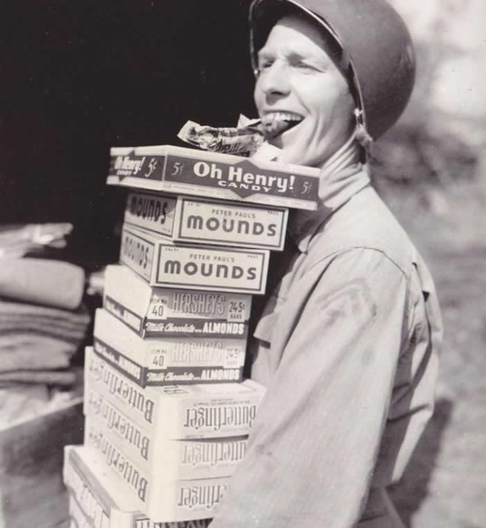 The Past Unfiltered: 36 Rare Historical Photos That Reveal the Human Side of History 65 A happy soldier carrying candy rations for his fellow troops in 1944.
