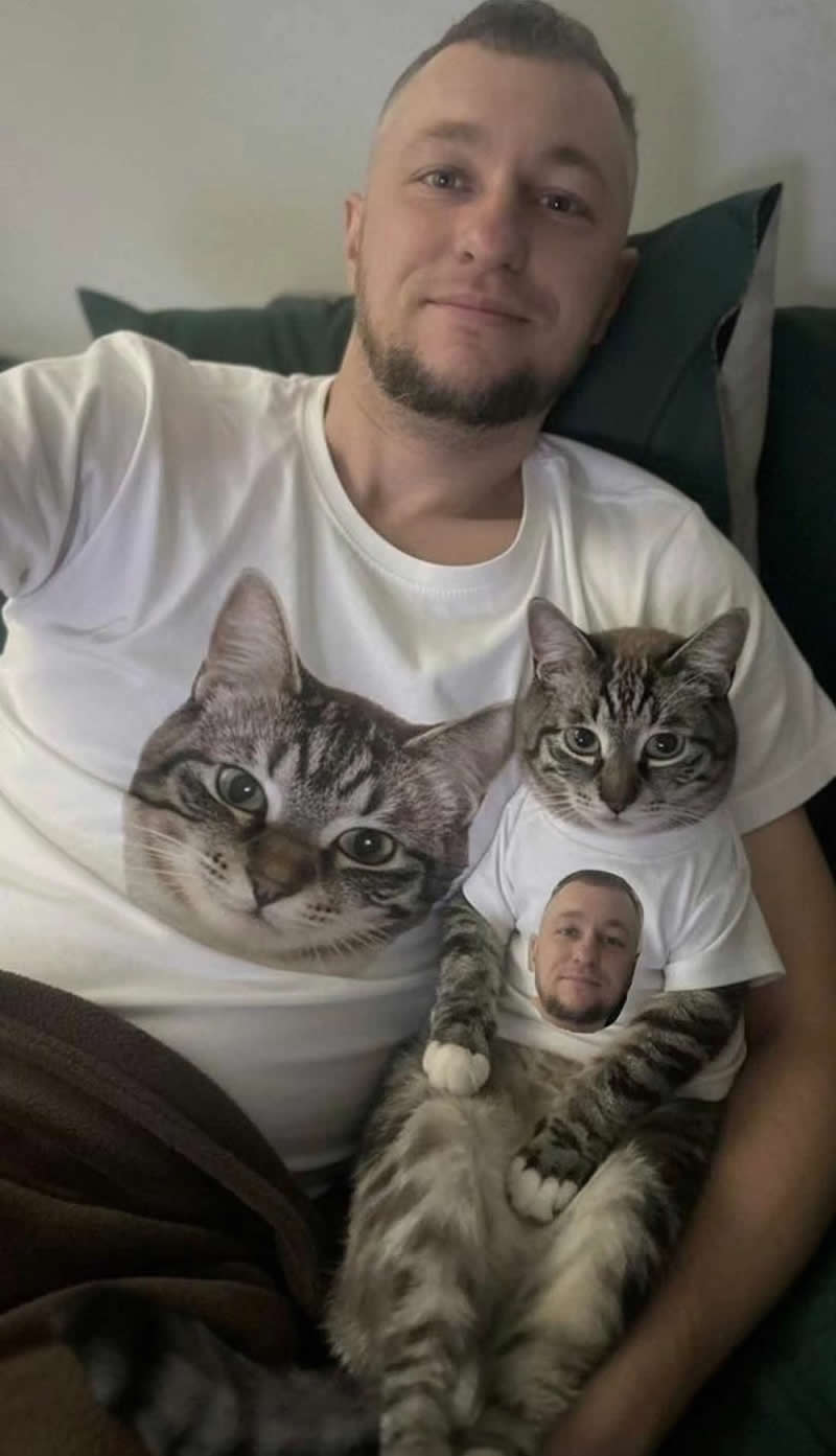 Too Cute to Handle: 35 Animal Photos That Perfectly Capture Everyday Chaos 70 A smiling man and his tabby cat sit together wearing custom matching T-shirts. The man's shirt features the cat's face, while the cat's tiny shirt features the man's face, creating a hilarious and heartwarming fashion statement that perfectly celebrates their special bond.