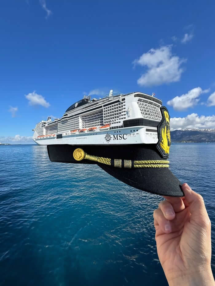 Pure Visual Magic: 35 Mind-Bending Forced Perspective Photos by Hugo Suíssas 57 A hand holds a black captain’s hat in the foreground, perfectly aligned with a large white cruise ship on calm blue water so the ship appears to be wearing the hat in a playful forced perspective illusion.