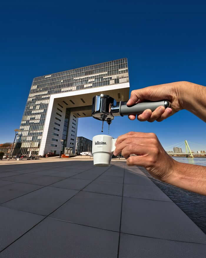 Pure Visual Magic: 35 Mind-Bending Forced Perspective Photos by Hugo Suíssas 41 A hand holds an espresso portafilter above a small coffee cup, aligned with a large modern arch-shaped building in the background so the building appears to pour coffee into the cup through a clever forced perspective illusion.